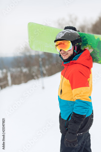 awesome young sportsman has finished snowboarding, side view close up photo, wellness, sporty life