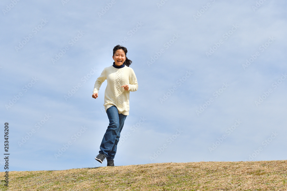 Japanese girl running in the blue sky Japanese girl running in the blue sky