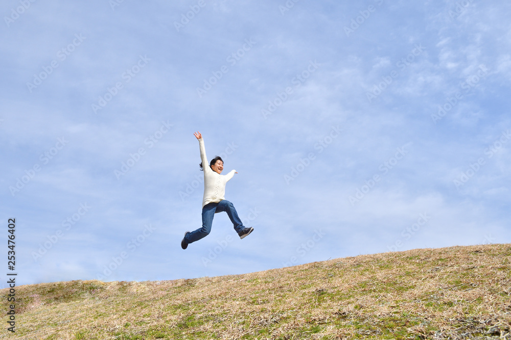Japanese girl jumping in the blue sky Japanese girl jumping in the blue sky