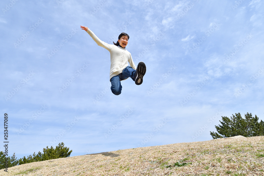 Japanese girl jumping in the blue sky Japanese girl jumping in the blue sky