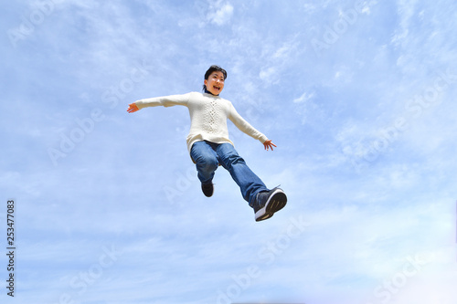 Japanese girl jumping in the blue sky