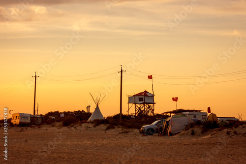 landscape creative home of aboriginal people on a wild vacation on the ocean with a wigwam and a tree house. the concept of free independent rebellious life in nature. sunset and toned