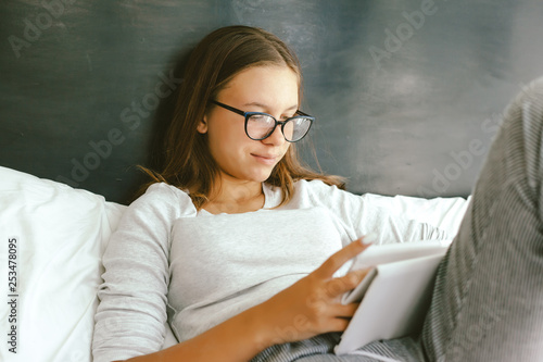 12-14 years teenag girl using tablet pc in room photo