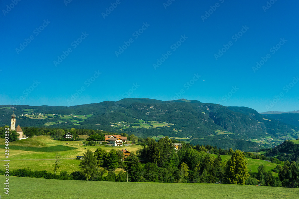 Italy, train from Bolzano to Venice, a large green field with a mountain in the background