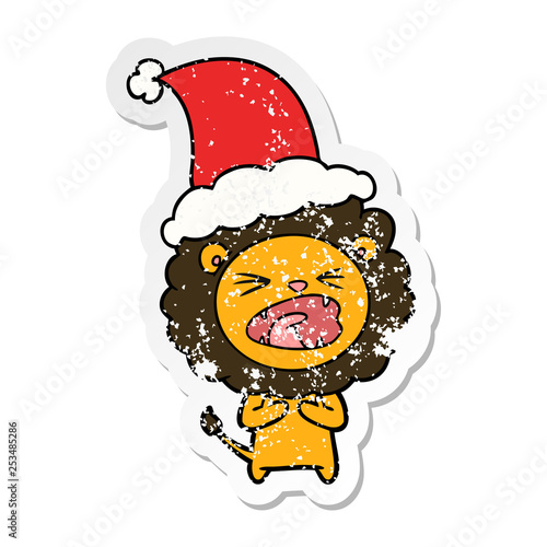 distressed sticker cartoon of a lion wearing santa hat photo