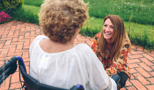 Foto Young woman caring elderly woman in a wheelchair