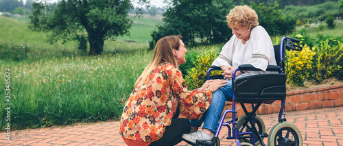 Konstfotografi Young woman talking to elderly woman in a wheelchair