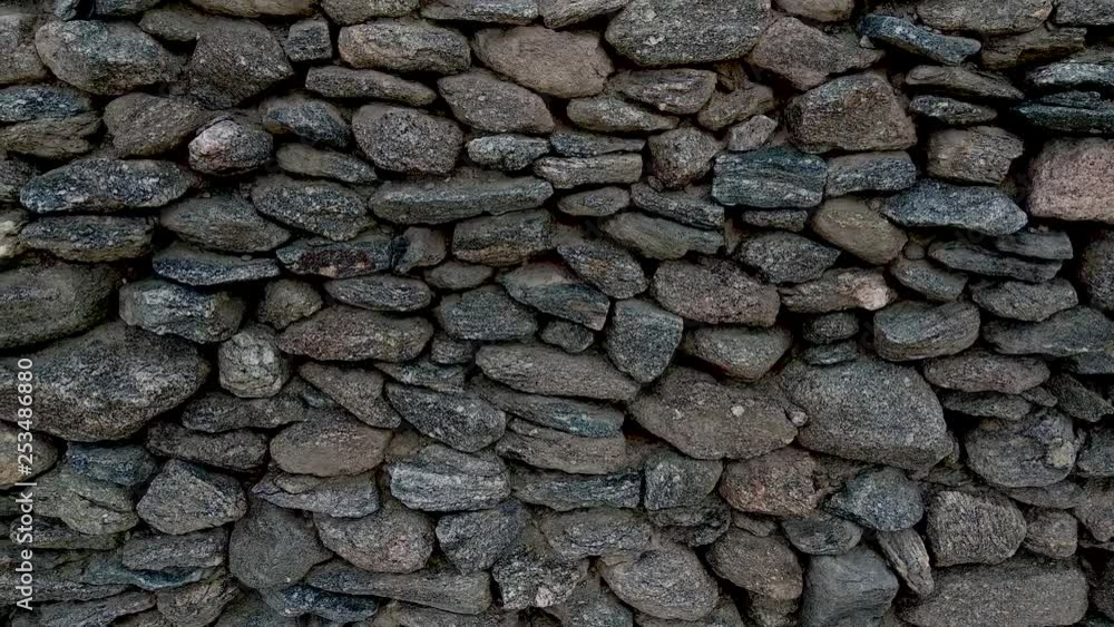 Close up panning shot of a hand-built asymmetrical stone wall. Close up panning shot of a hand-built asymmetrical stone wall.