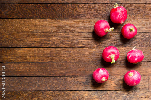 Red radishes on wooden table with copy space