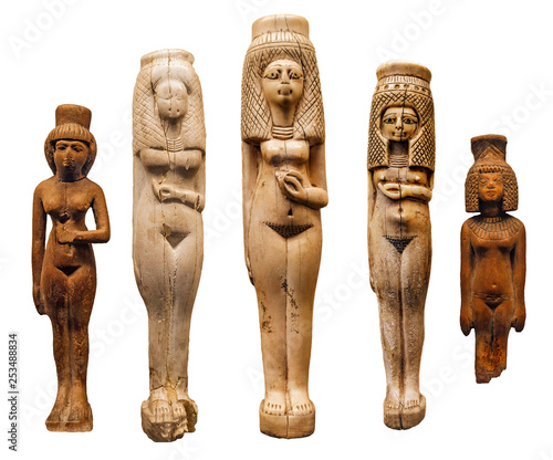 Ancient Egyptian bone figurines of women isolated over a white background.