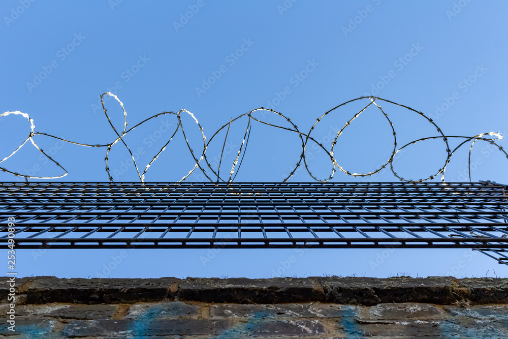 Barbed wire on blue sky background - Lost freedom and hope concept Barbed wire on blue sky background - Lost freedom and hope concept