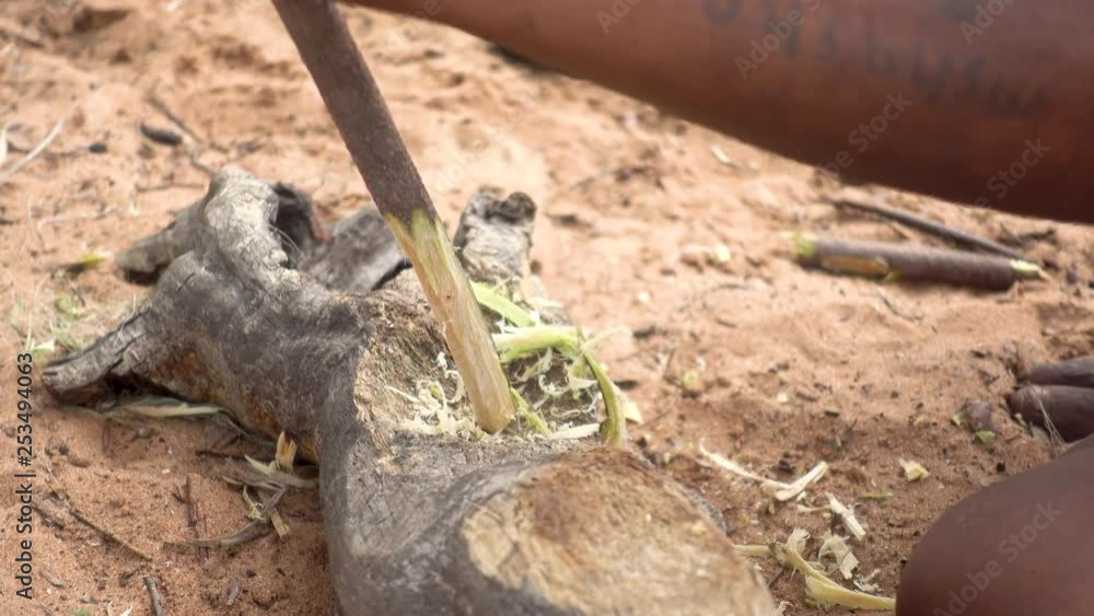 Close-up of African Man Splicing Wood with Axe to make an Arrow Close-up of African Man Splicing Wood with Axe to make an Arrow