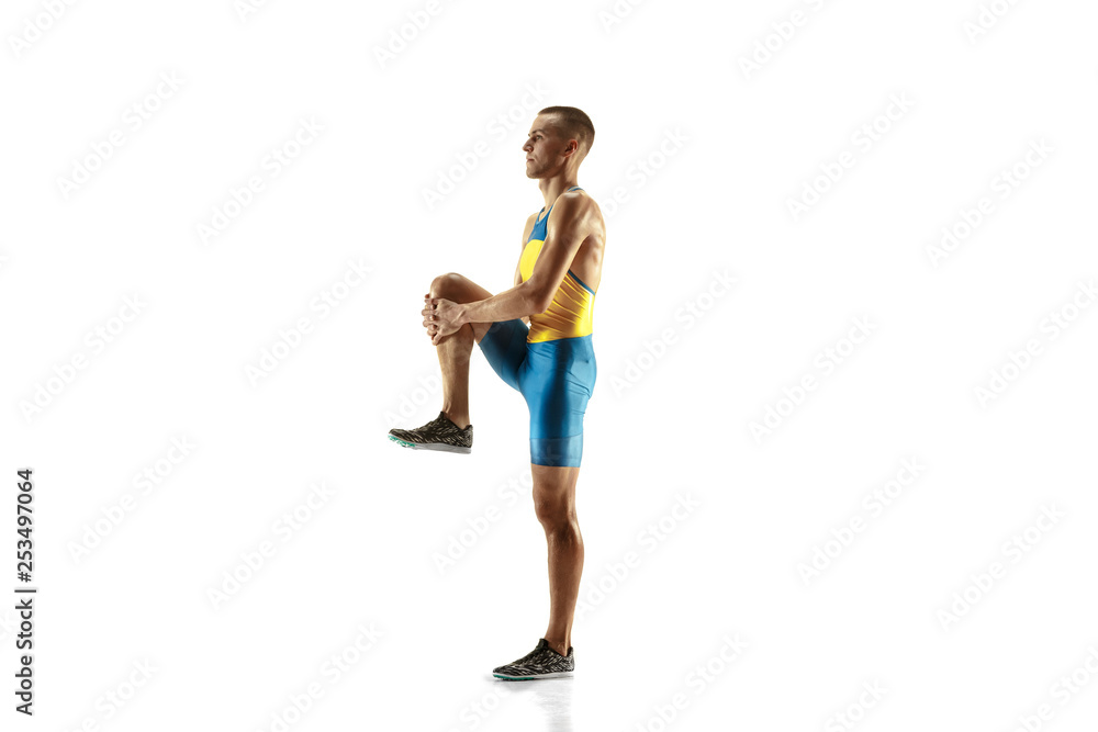 Young caucasian man warming up before run isolated on white studio background. One male runner or jogger. Silhouette of stretching athlete with shadows. Young caucasian man warming up before run isolated on white studio background. One male runner or jogger. Silhouette of stretching athlete with shadows.