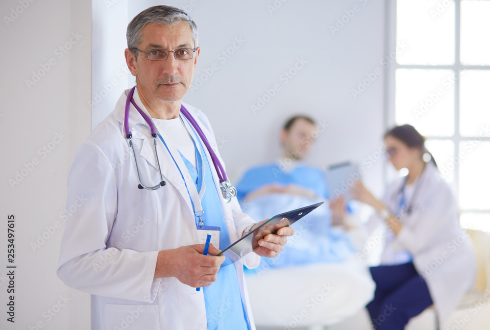 Doctor holding folder in front of a patient and a doctor