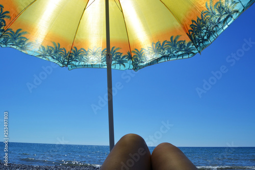 Obraz na płótnie On the sea under an umbrella w salonie