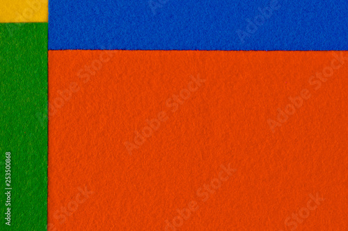Pieces of coloured felt. Orange, yellow, green and blue color composition. Colorful felt texture for background with copy space.