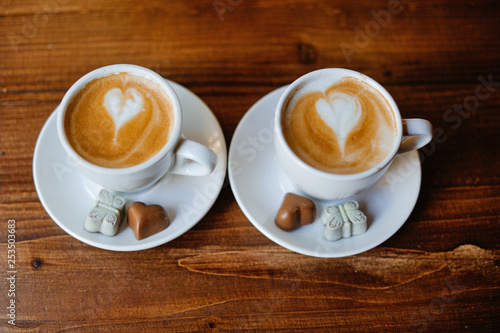Two white cups with espresso on wood table