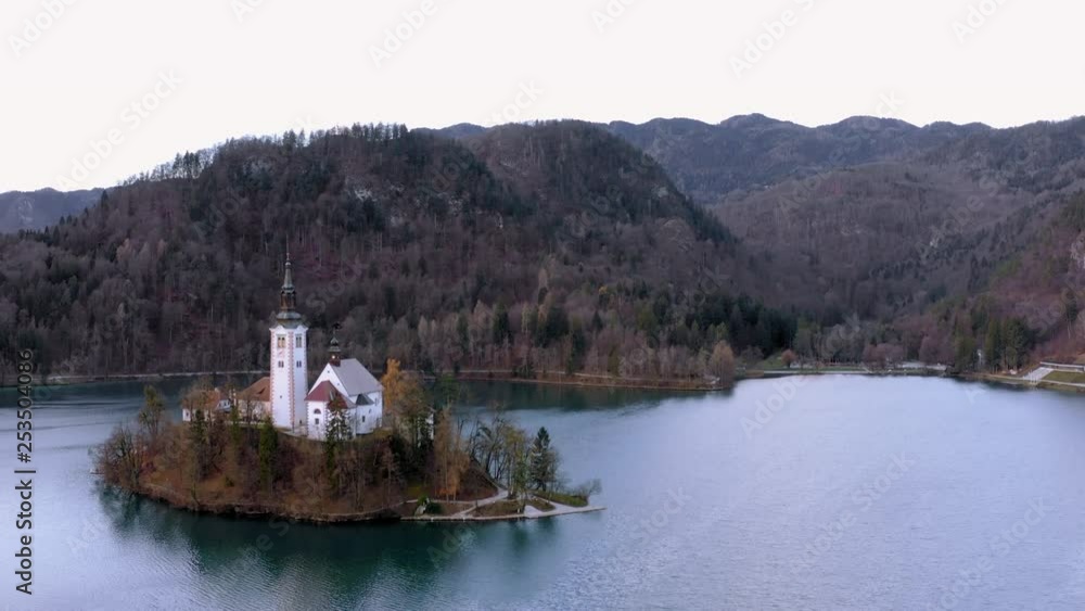 Beautiful close of the Bled island with the Pilgrimage Church of the Assumption on Mary in a cloudy day. Bled Slovenia. Aerial view traveling Beautiful close of the Bled island with the Pilgrimage Church of the Assumption on Mary in a cloudy day. Bled Slovenia. Aerial view traveling