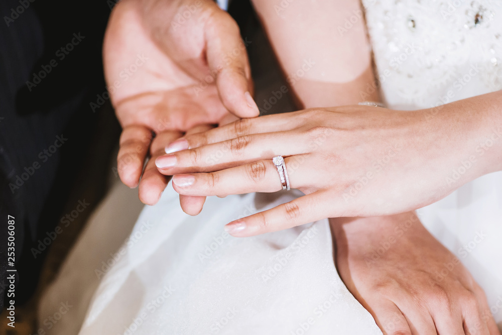 The groom holding the bride hand after put the wedding ring on her finger The groom holding the bride hand after put the wedding ring on her finger