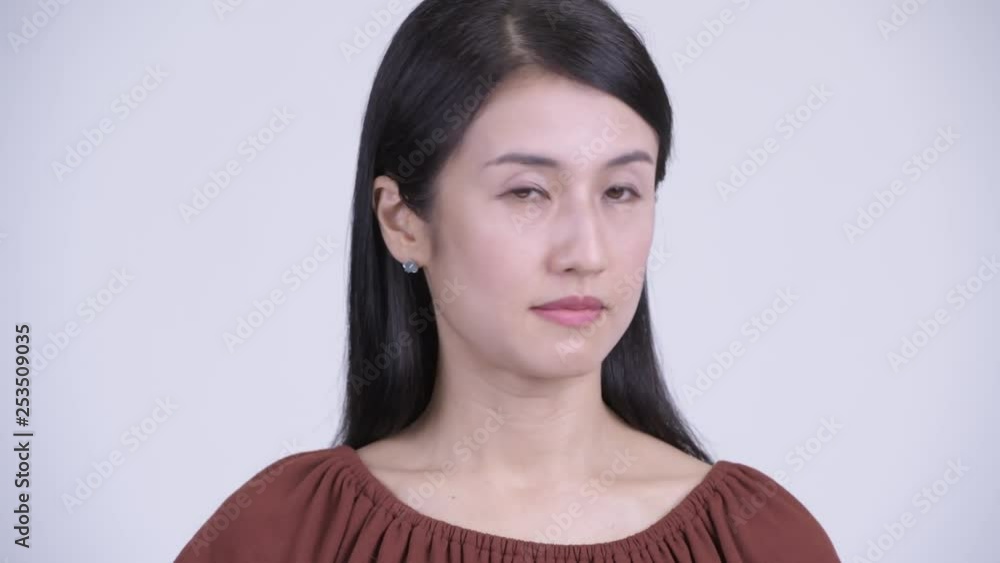 Face of serious Asian woman nodding head no Face of serious Asian woman nodding head no