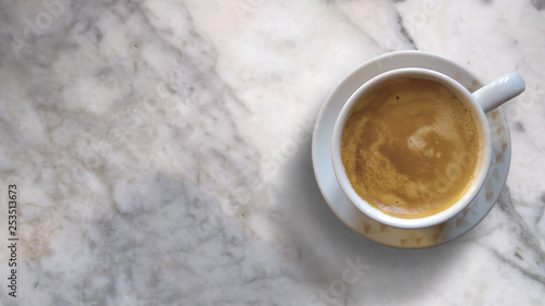 Mug with hot coffee on a marble table. Top view background and empty copy space for Editor's text.