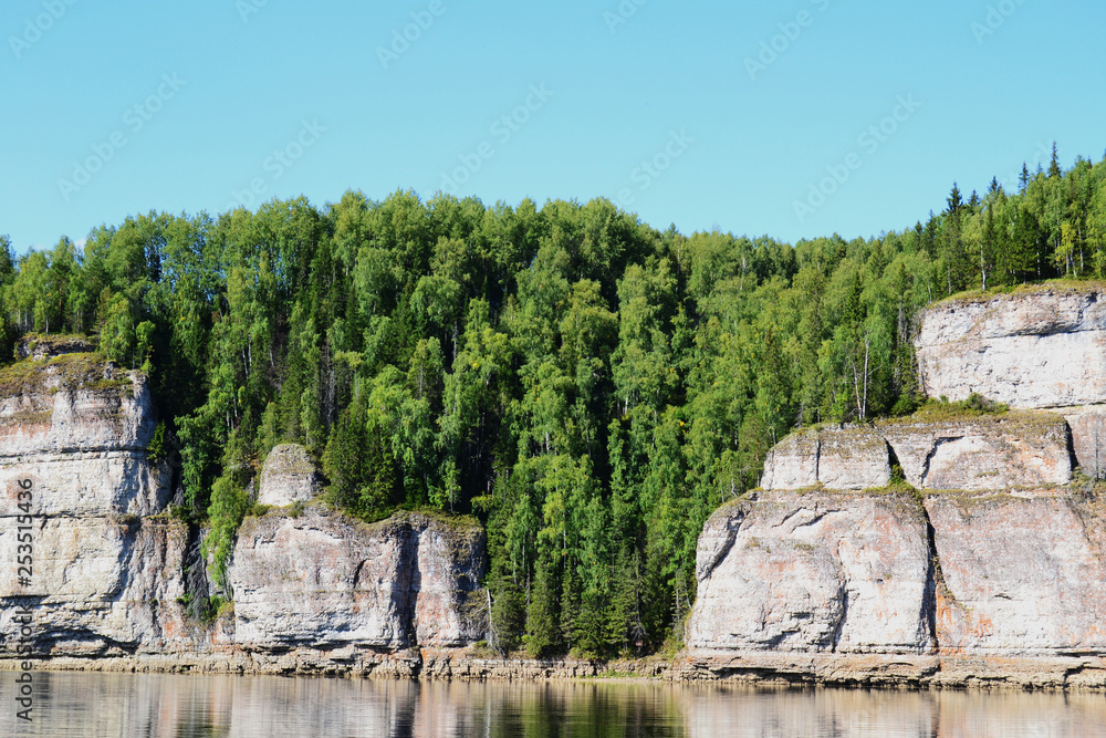 Rocky coast with forest on the river