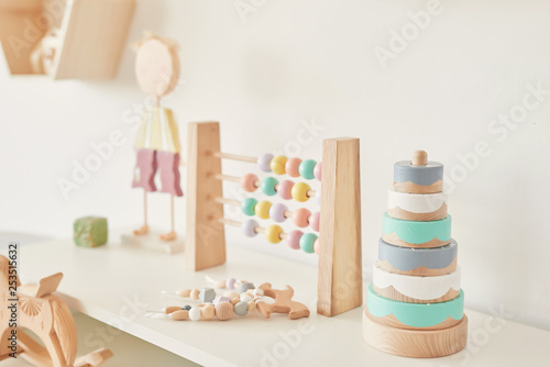 wooden toys in the children's room, chest of drawers and a white bed, the interior of the children's bedroom