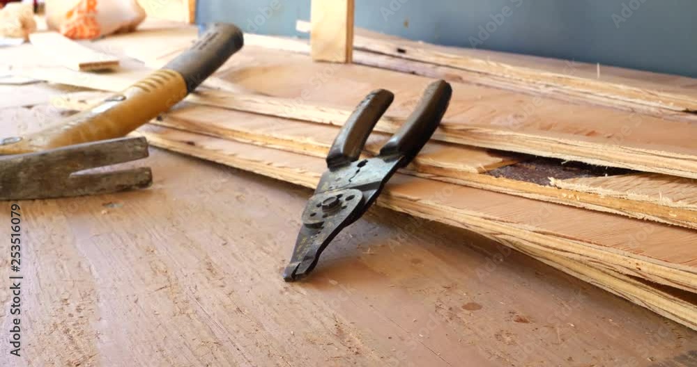 A set of electrician wire strippers and a hammer on the construction site of a new building. A set of electrician wire strippers and a hammer on the construction site of a new building.