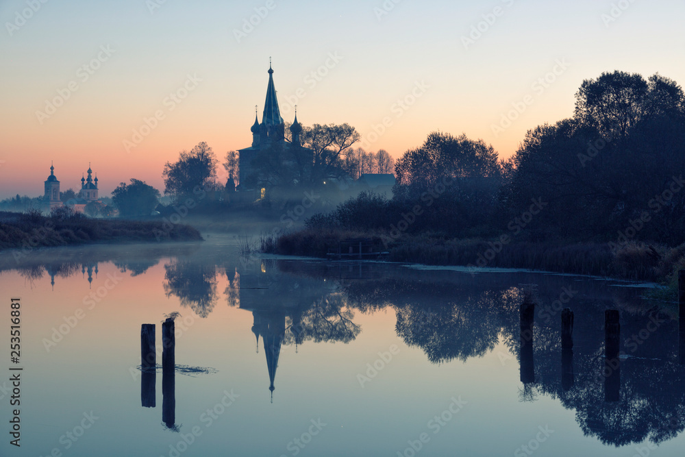 Old churches  at fog sunrise in Dunilovo, Russia