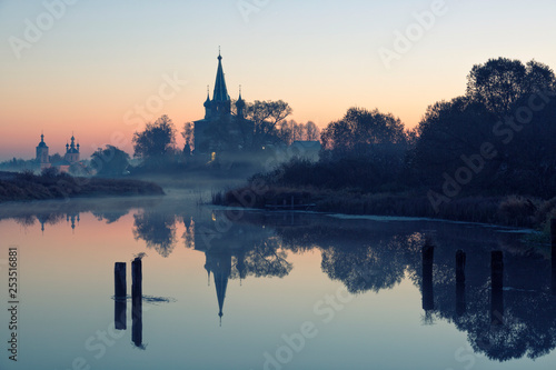 Old churches at fog sunrise in Dunilovo, Russia