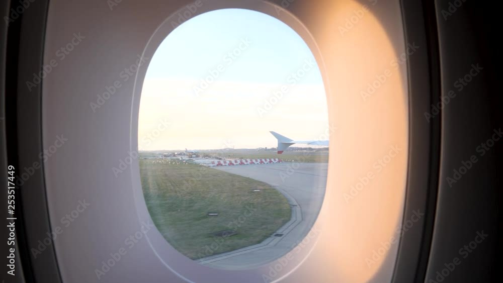 Airplane taxiing on the runway at Airport, Viewpoint from a passenger window, going past with plane in the background and the sun shining in, 4k Airplane taxiing on the runway at Airport, Viewpoint from a passenger window, going past with plane in the background and the sun shining in, 4k