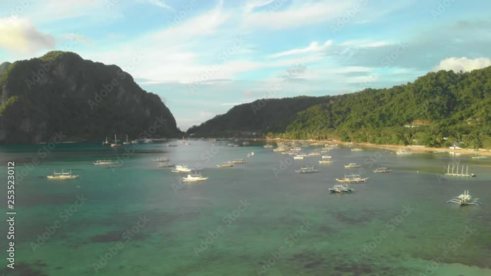 Drone circling around a lot of boats in front of a beach in El Nido. Exploring and adventure concept. Drone circling around a lot of boats in front of a beach in El Nido. Exploring and adventure concept.