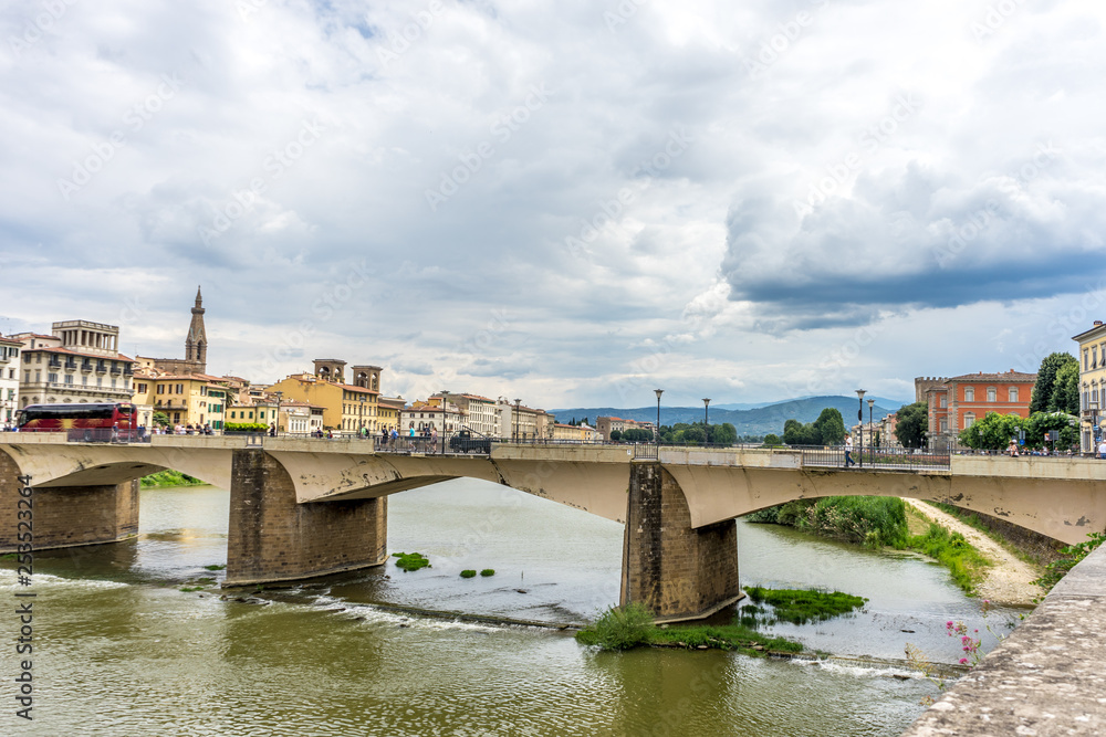 Italy,Florence, a train crossing a bridge over a river