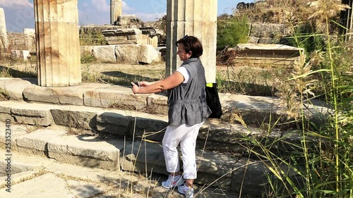 Woman takes picture in ancient city Magnesia (Aydin Province, Turkey).