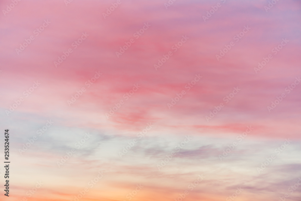 Sunset sky with pink yellow light clouds. Colorful smooth blue sky gradient. Natural background of sunrise. Amazing heaven at morning. Slightly cloudy evening atmosphere. Wonderful weather on dawn.