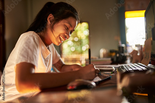 thai teen girl doing homework and studying at home photo