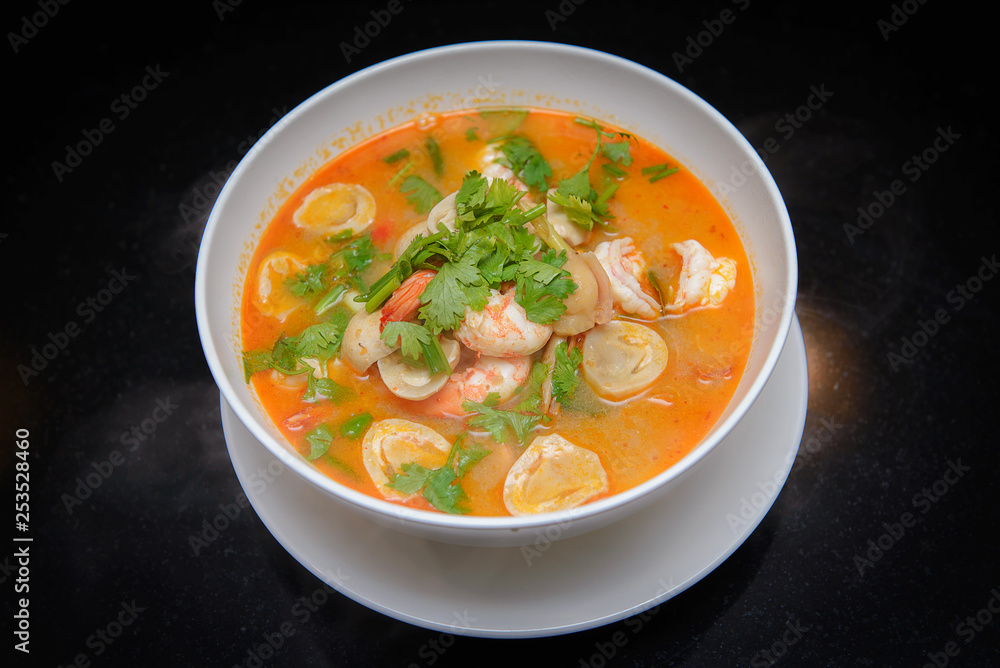 Tom Yum Goong spicy soup traditional food cuisine in Thailand , Top view on black background Tom Yum Goong spicy soup traditional food cuisine in Thailand , Top view on black background