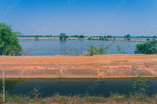 View of Water management in the rice fields from the irrigation canal before planting in Kanchanaburi, Thailand.