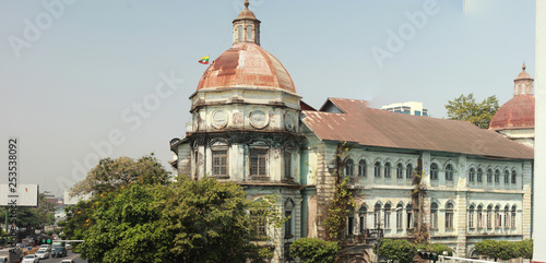 panorama of a busy street intersection in central Yangon, Myanmar, Southeast Asia, with traffic and old deteriorating British colonial buildings