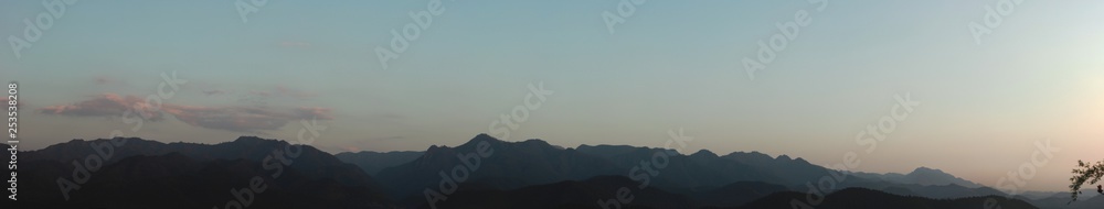 wide panorama of hills and mountains on a nice cloudy evening from a hill top in Northern Thailand, Southeast Asia