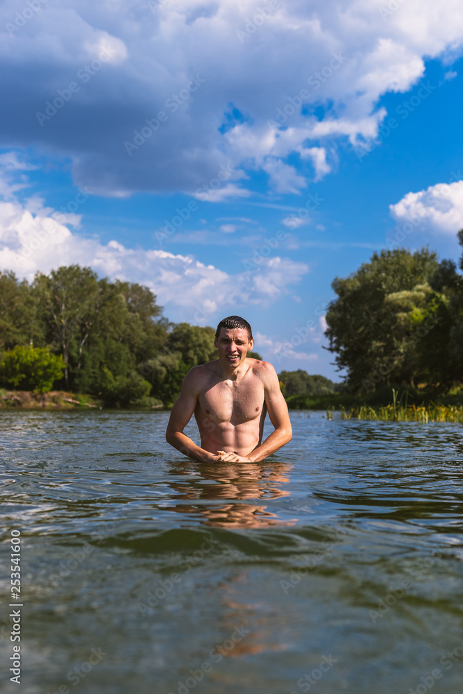 Fototapeta premium Portrait of a handsome young man in the water.