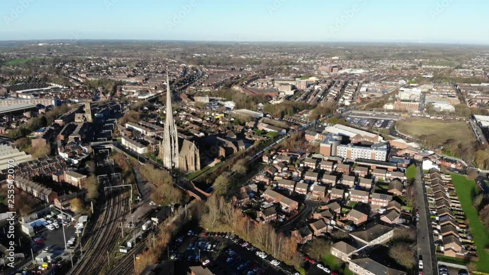 An aerial view of Church of St Walburge, Preston and a very long train moving on the tracks on a winter sunny day An aerial view of Church of St Walburge, Preston and a very long train moving on the tracks on a winter sunny day