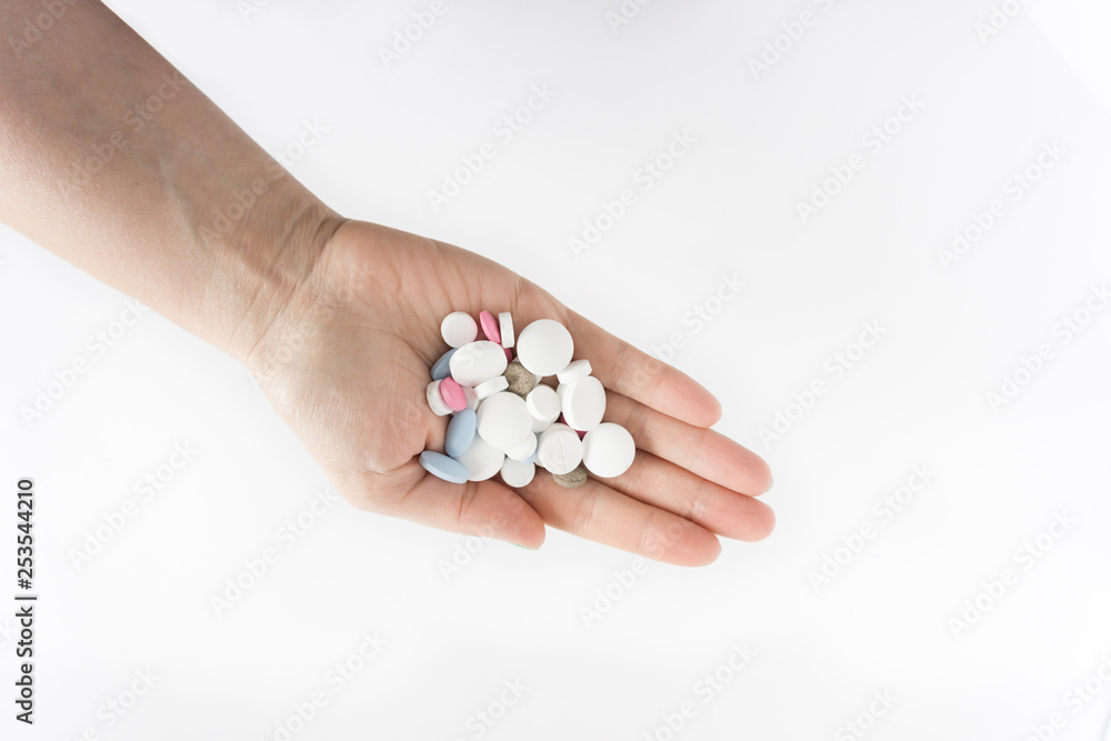 pills red blue white different shapes on female hand white background