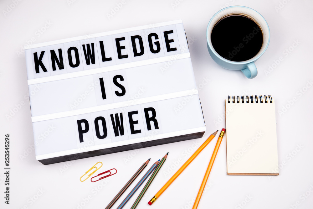 Knowledge is power. Text in lightbox. White desk with stationery Knowledge is power. Text in lightbox. White desk with stationery