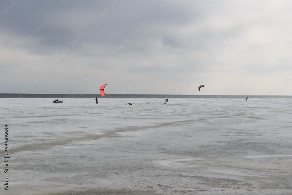 Snowkiting by the sea in spring with melted snow and ice
