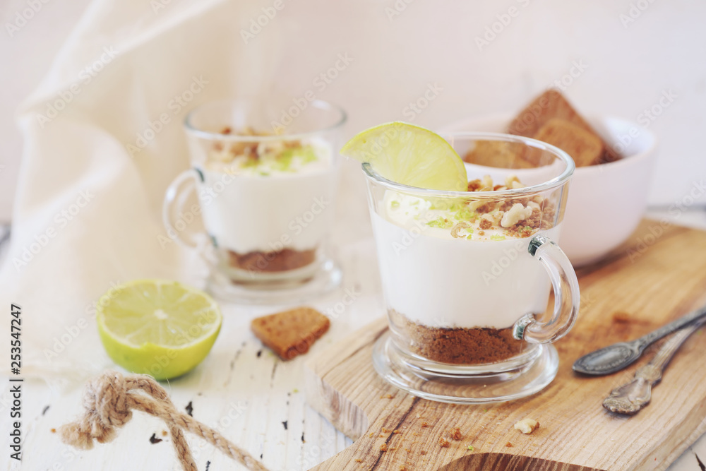 Lime cheesecake in two cups on light background