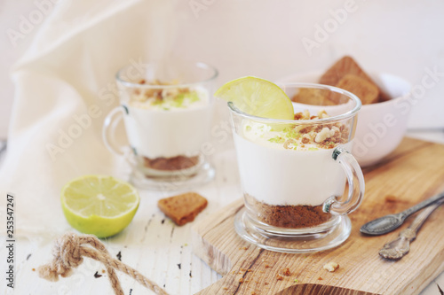 Lime cheesecake in two cups on light background