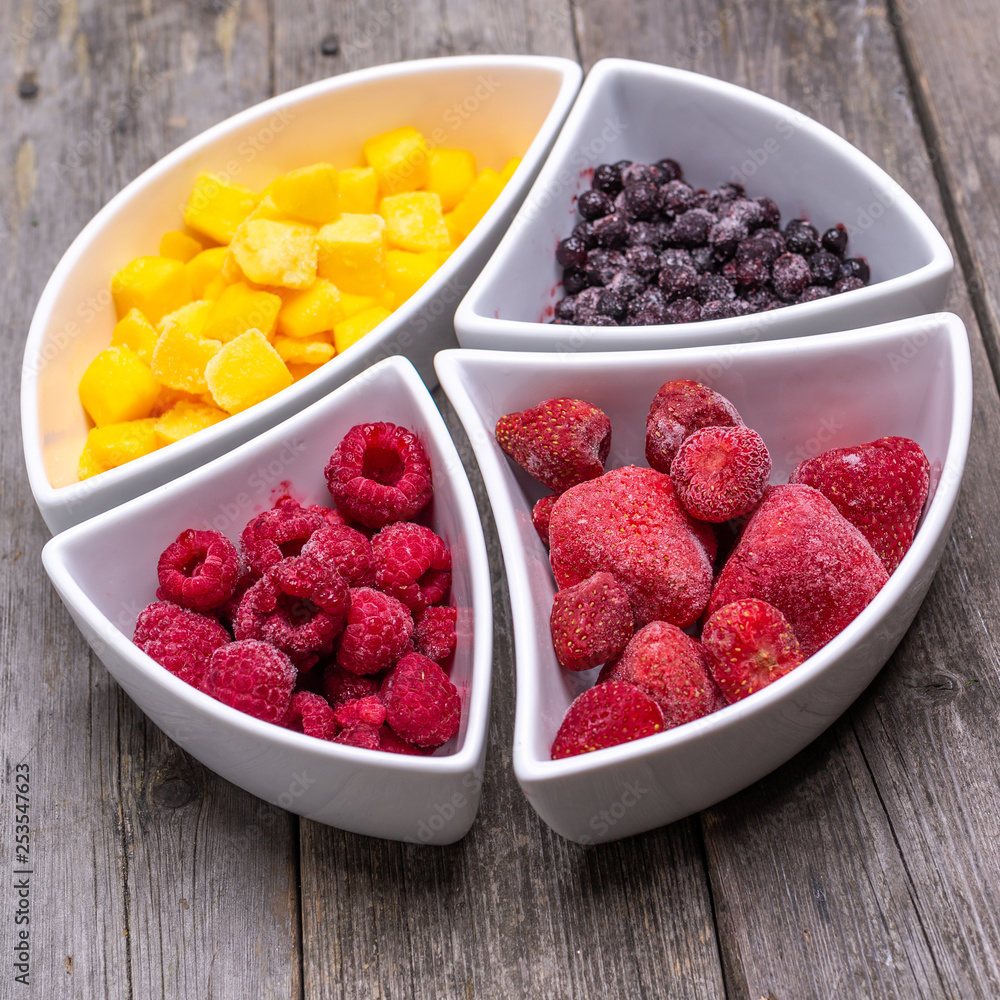 healthy berries and fruit in shaped bowls on wooden talbe healthy berries and fruit in shaped bowls on wooden talbe