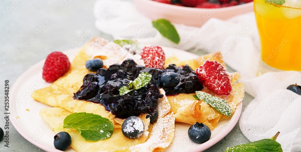 French crepes with blueberry compote topping, selective focus French crepes with blueberry compote topping, selective focus