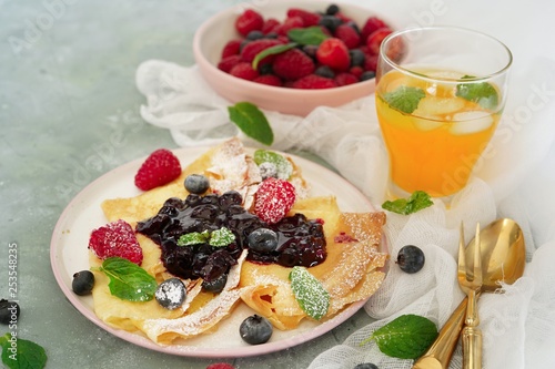 French crepes with blueberry compote topping, selective focus